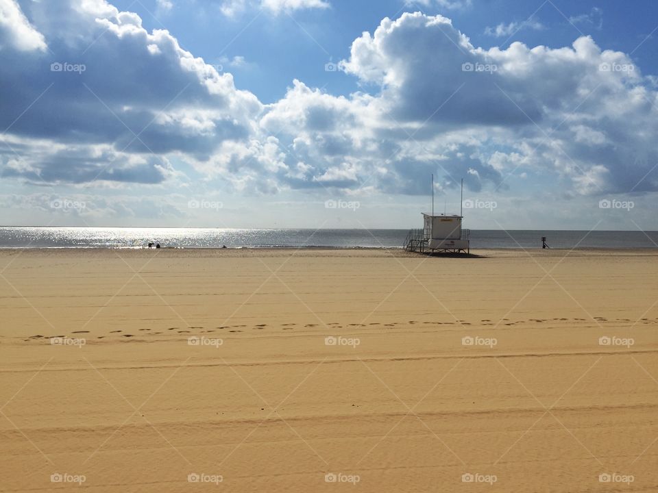 Sunny Golden Beach in UK. Lowestoft beach with lifeguard station and people playing.