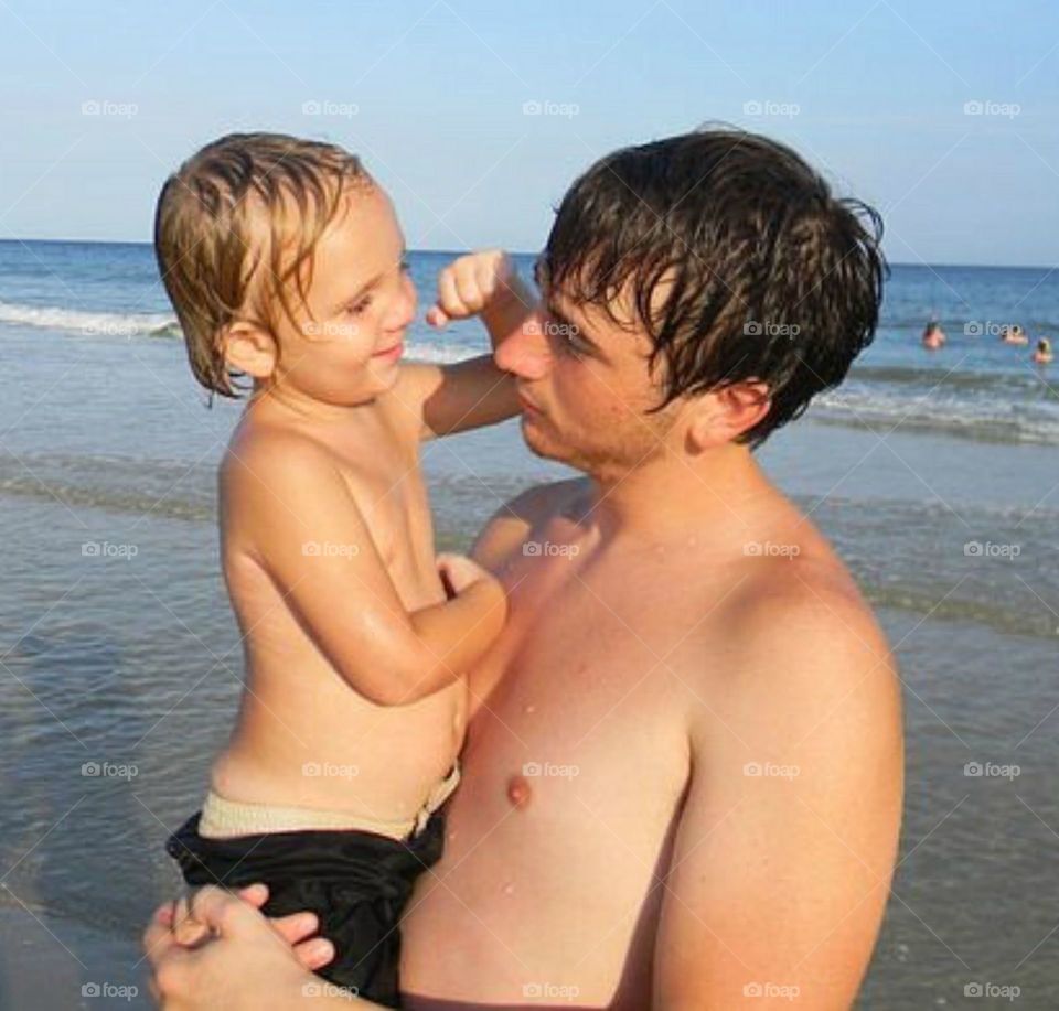 Father carrying his daughter at beach