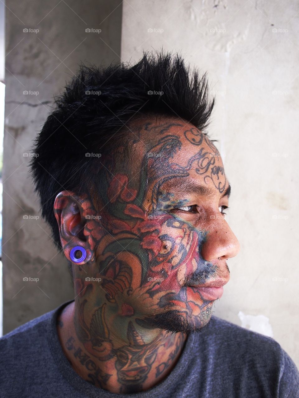 portrait of a man with facial tattoo