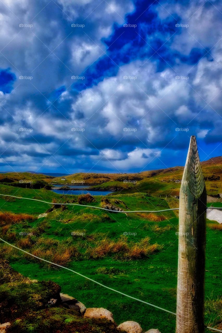 Clouds over Scotland landscape, white puffy clouds stand out against Scotland landscape, view from the church, Scotland’s beauty, clouds in the blue sky, big beautiful sky over Scottish land 