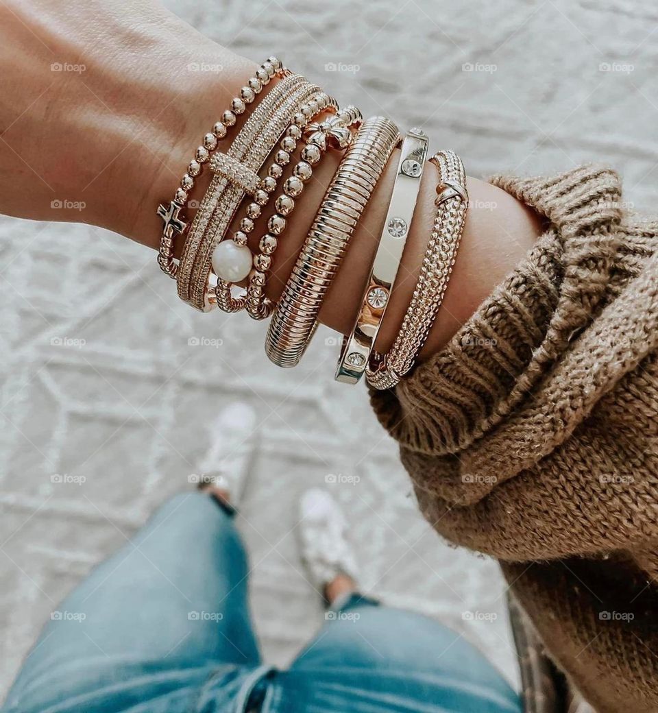 Golden bracelet jewelry on woman wrist arm hand outfit