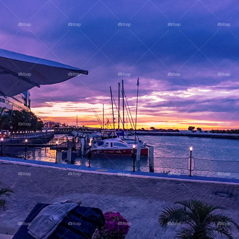 Sunset at the Marina in Fortaleza, Brazil.  Beautiful view of the boats moored in the Marina at the end of the afternoon, with the last rays of the sun between the clouds of purple collaboration, reflecting on the shore.