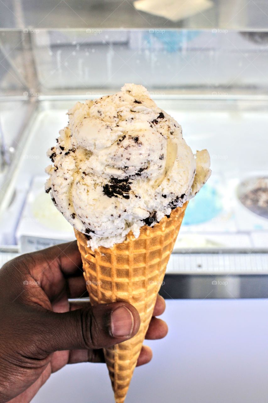 Persons hand holding on waffle cone