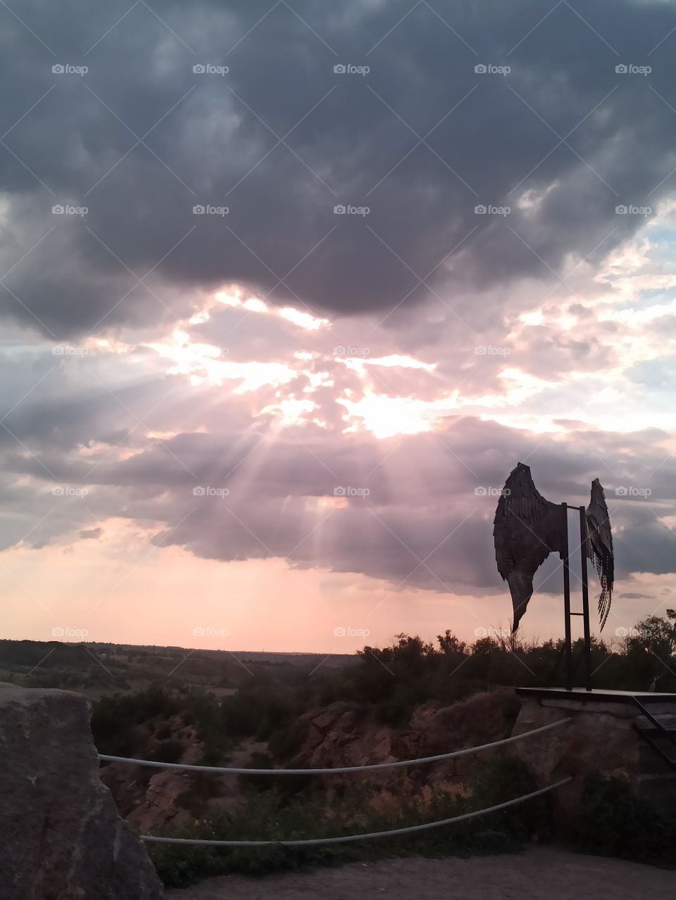 Sunrise. The sun's rays make their way through the clouds. Wings.