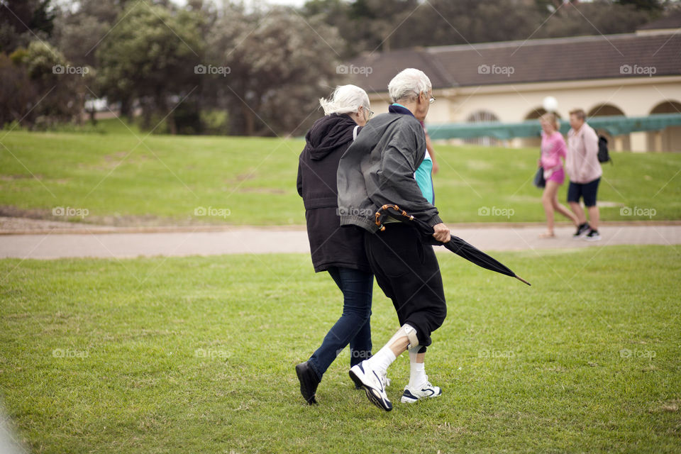 old couple walking during the cold days in the park