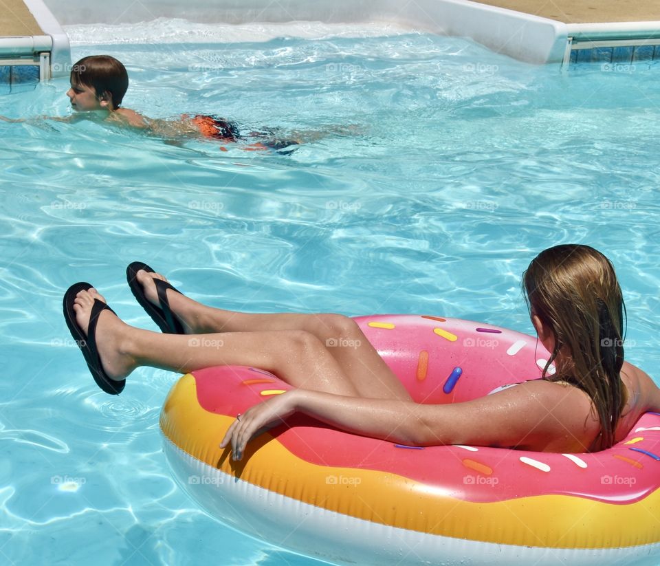 Relaxing in the swimming pool by floating on a donut tube