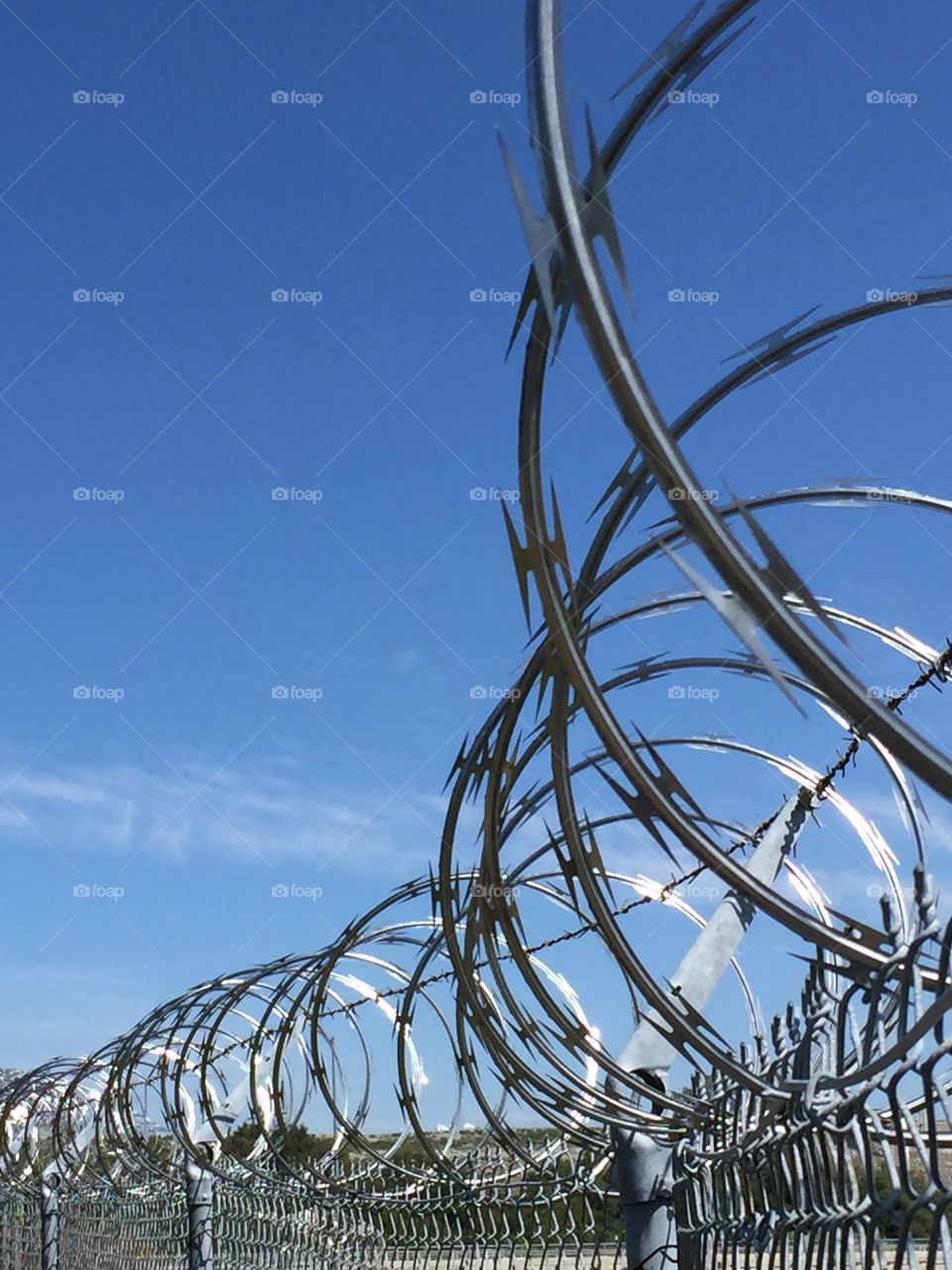 Razor wire fence against clear sky