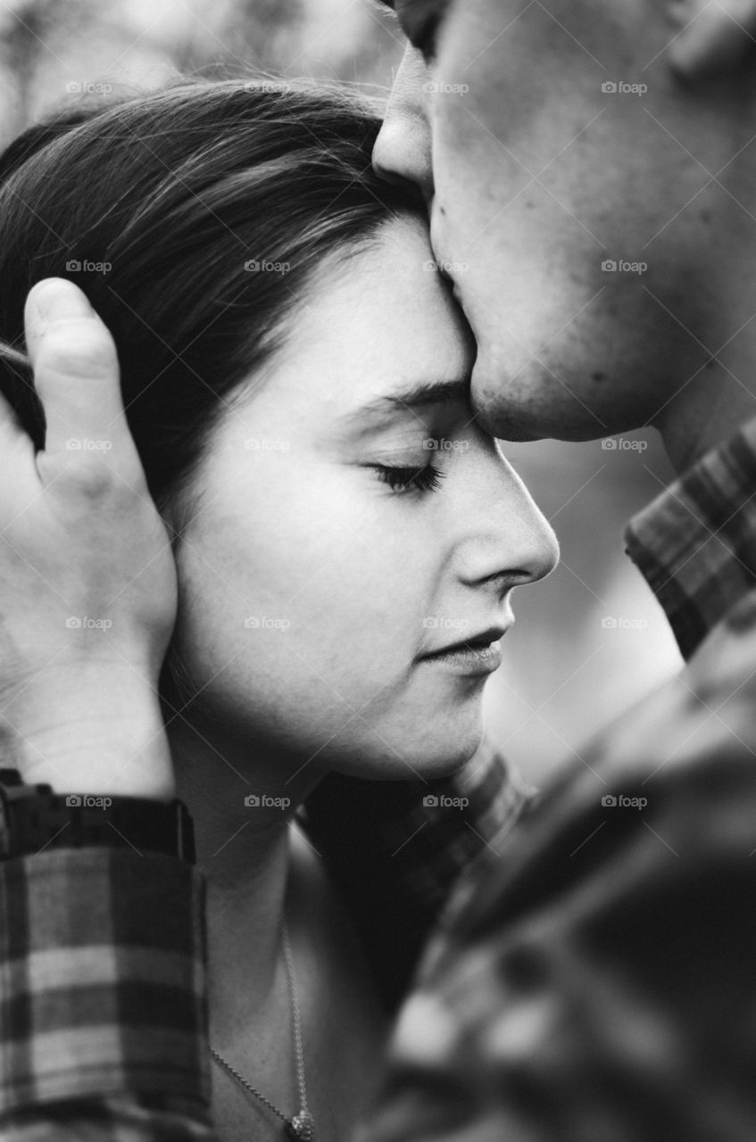 Man kissing woman's forehead