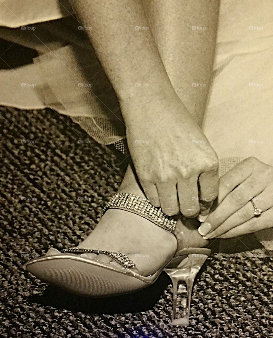 Bride putting on her wedding shoes
