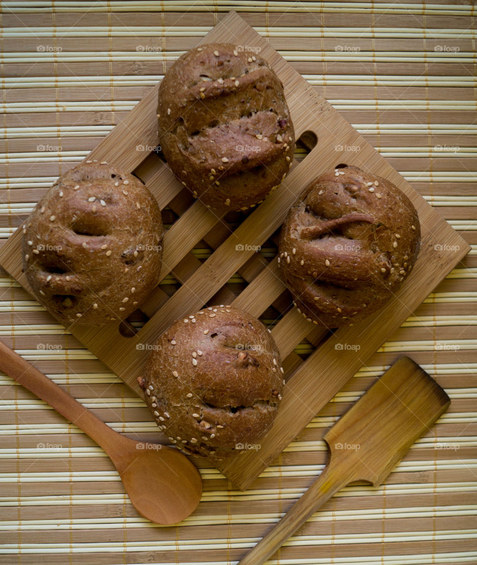 three little homemade breads with stripped background and woody spoons