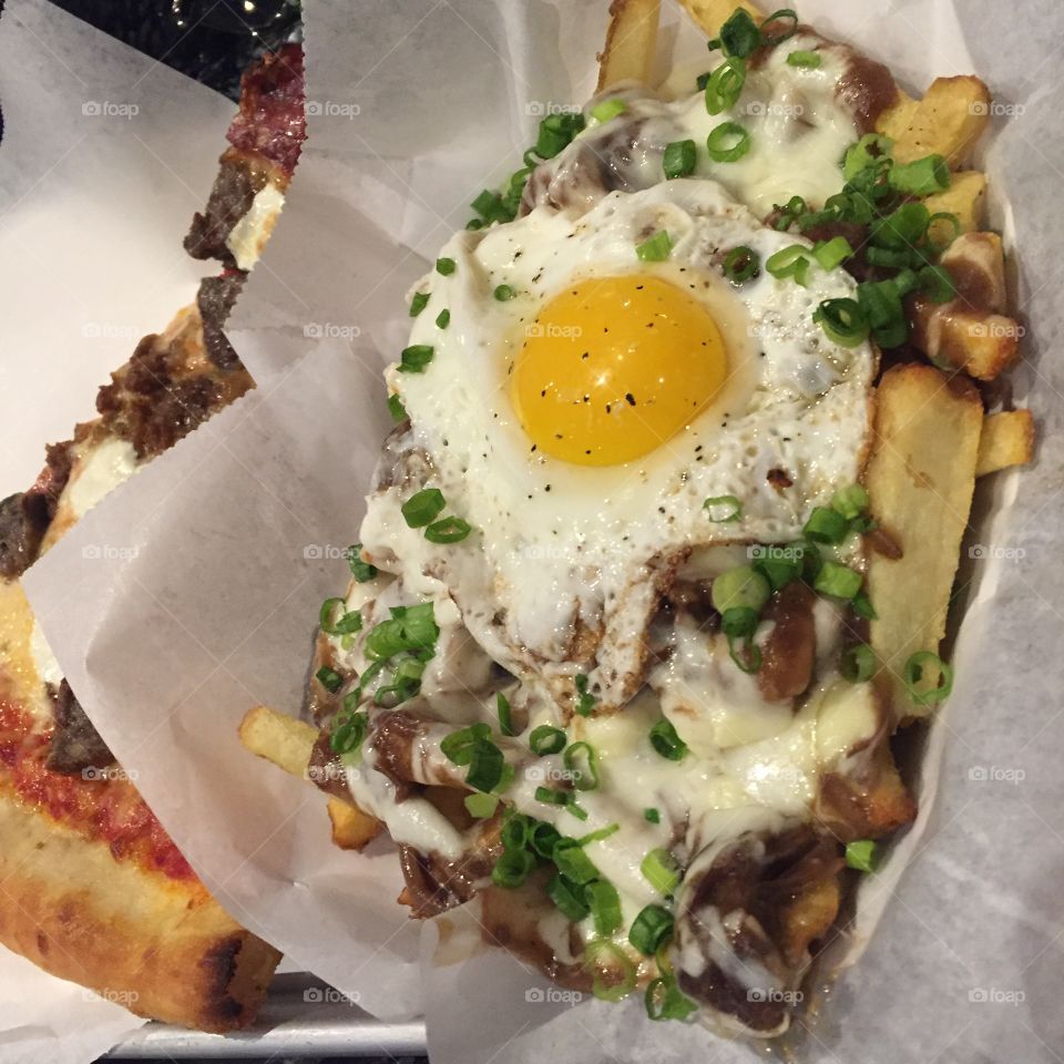 Poutine, sunny side up egg, beef, french fries, chopped green onions 