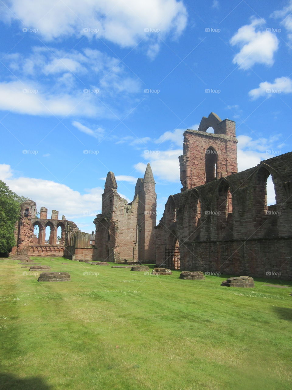 Ruined Scottish church with green grass and blue sky 