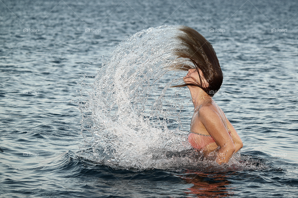 Woman tossing her hair in sea