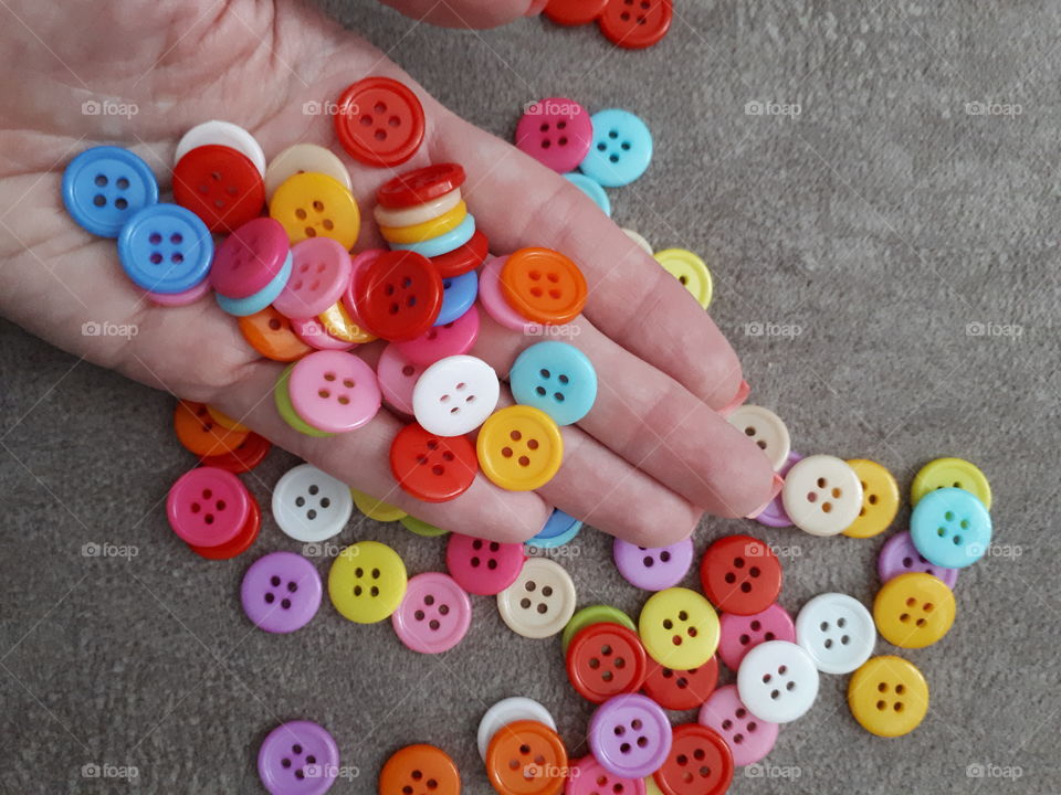 Many colored buttons on the woman's hand