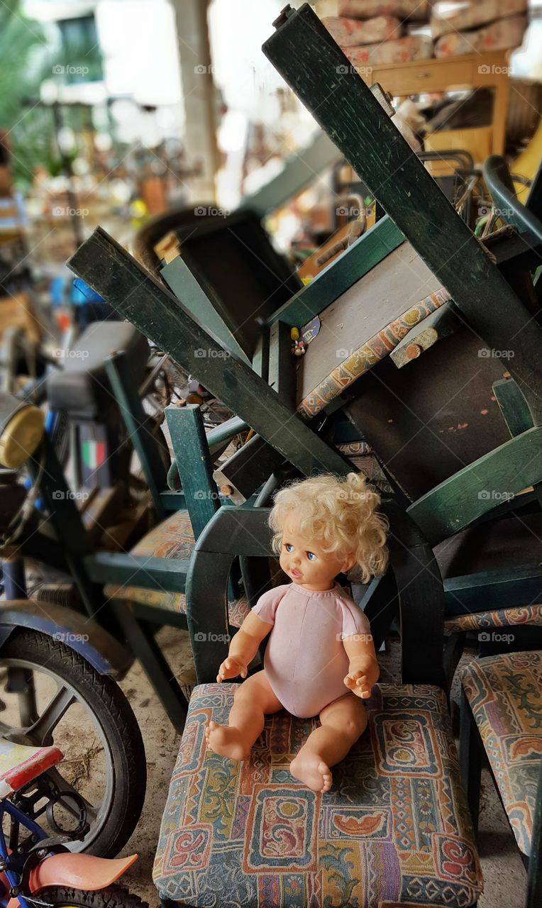 old doll forgotten in a pile of mess