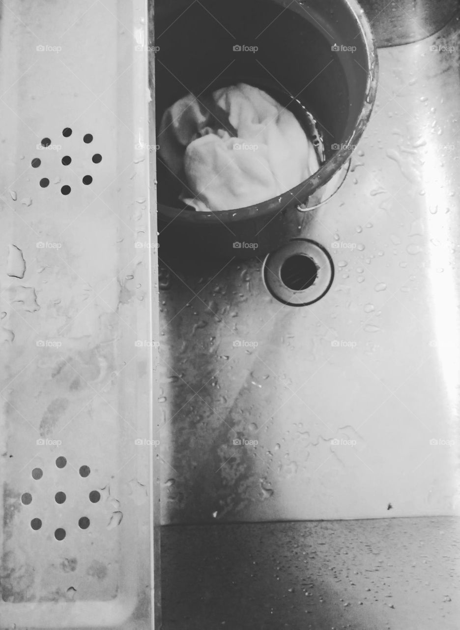 Laundry sink, with a bucket of and circles on the upper drain and bottom drain