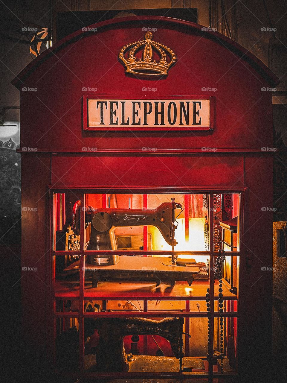 Vintage telephone booth turned into a display with vintage sewing machines 