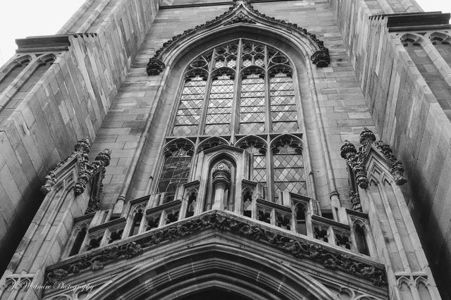A closeup of the intricacies of the Trinity Church in New York City and the stained glass above the main entrance
