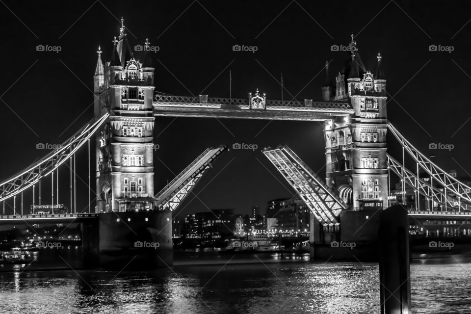 London tower bridge opened up in black and white. 