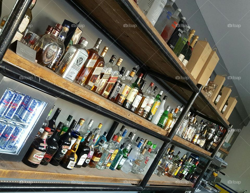 A line of liquor bottles at a bar on a shelf