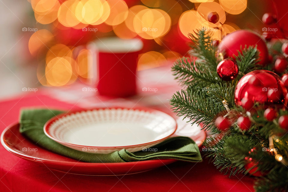 Festive winter cozy kitchen interior with garlands, decorations and gifts.  Christmas dinner at the decorated table.