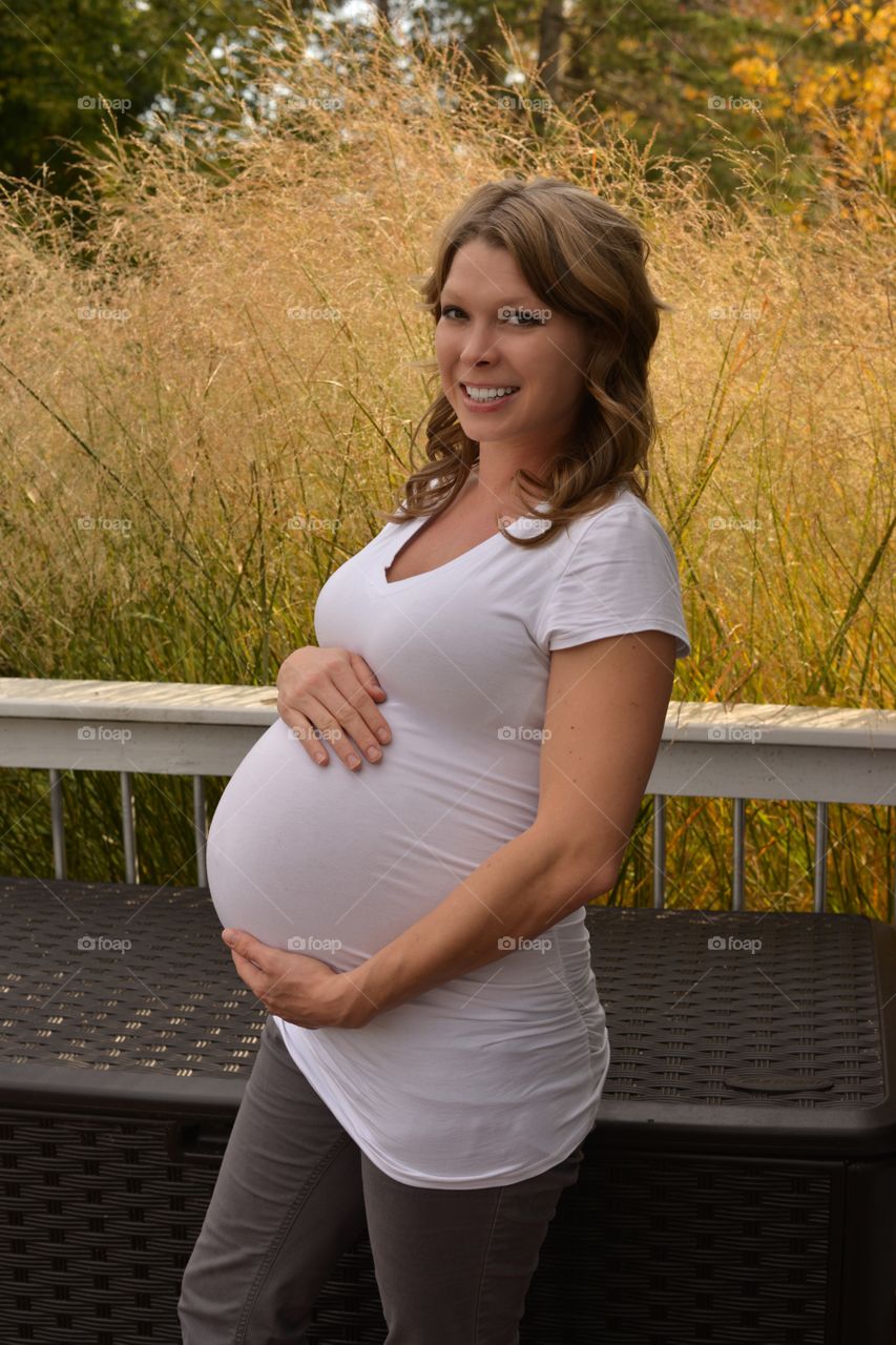 Smiling pregnant woman touching her belly