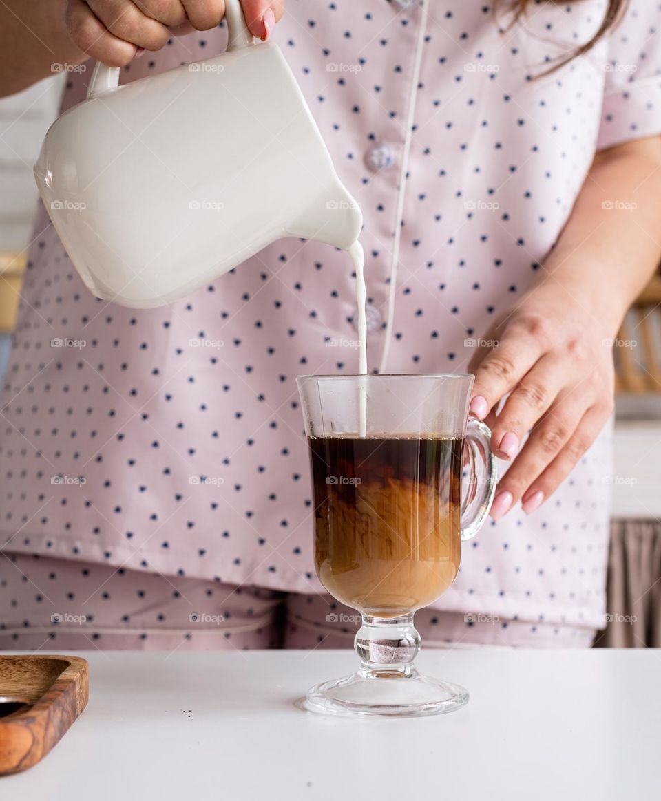 woman in pink pajamas pour coffee