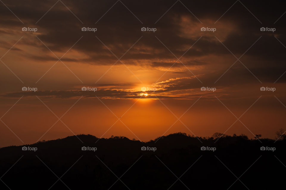 The sun is cut with dark clouds at sunset