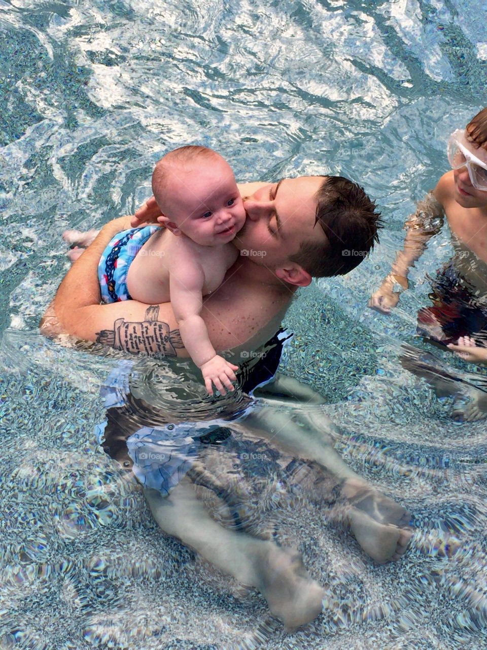 Father and baby boy in swimming pool