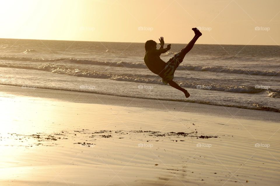 Man playing capoeira in the beach 