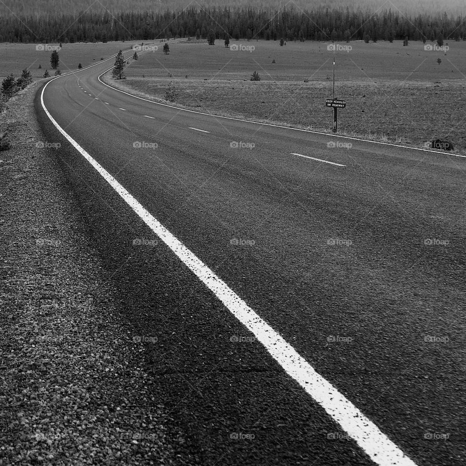 A road curves as it leaves the Pumice Desert in Southern Oregon and continues on to Crater Lake. 