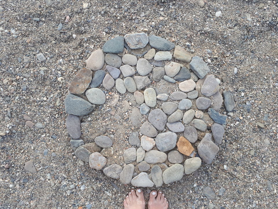 Women's barefeet near stones monument at the beach