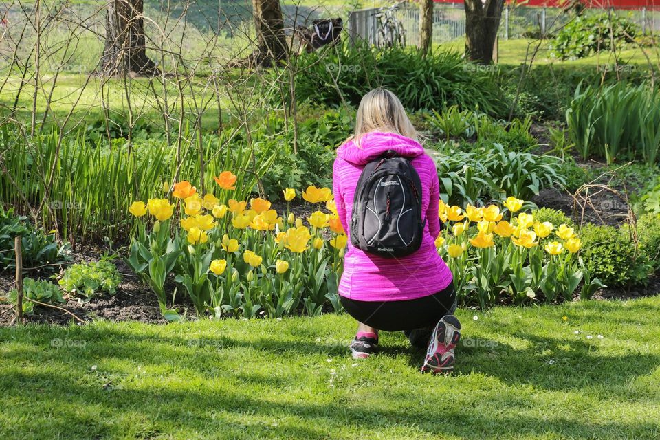 Back view of girl talking photo of flowers 