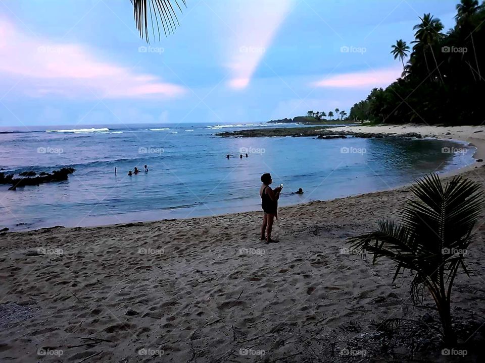 My aunt documenting the setting sun. Off the Pacific coast in the Philippines.