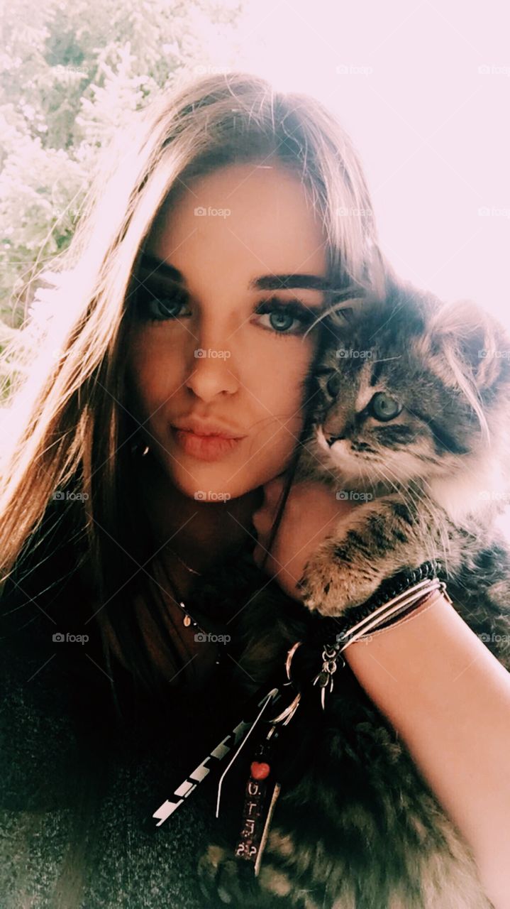 A pretty girl and a little kitten with a sweet face.