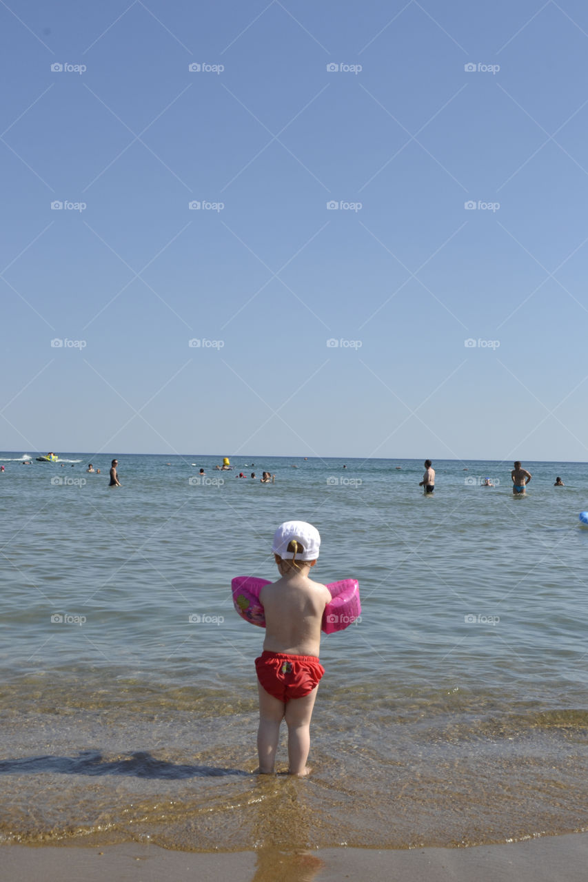 Two year old girl taking her first swim on their family holiday in Turkey.