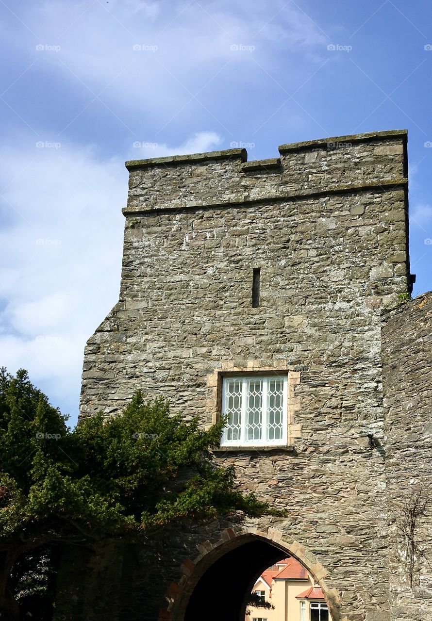 The historical architecture of Lee Abbey against the beautiful spring sky. The lines and stone against the cloudy sky. 