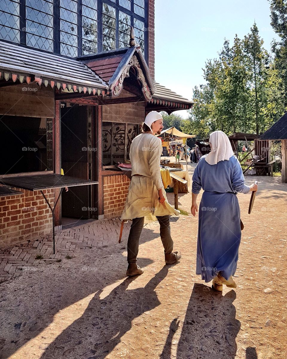 A man and a woman are in street in Middle Ages