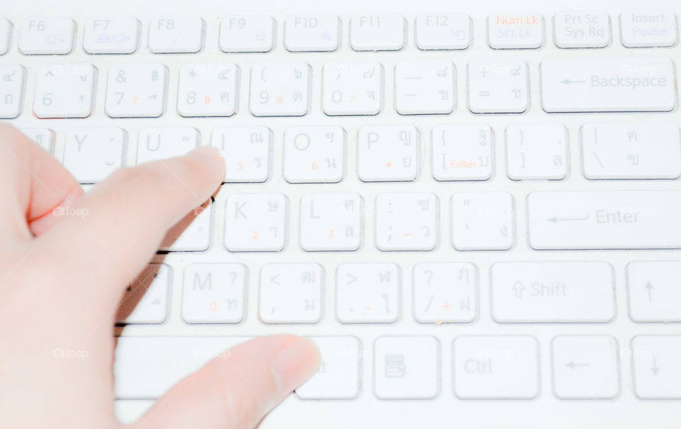 left hand typing on keyboard with soft focus