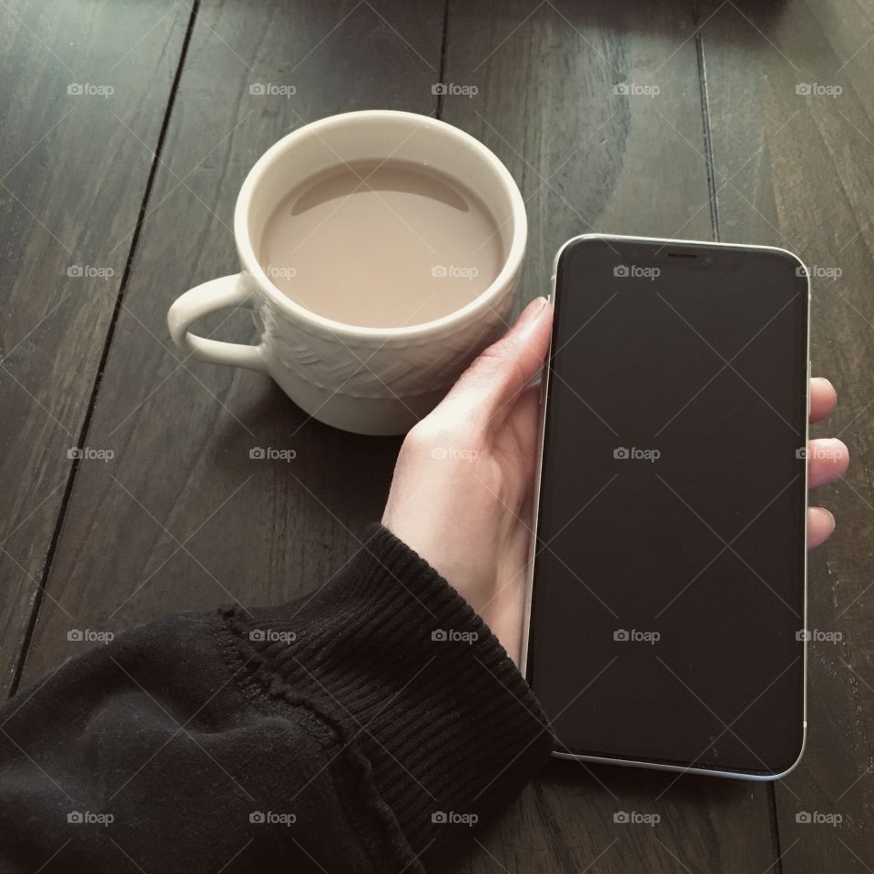 Morning coffee at the table with phone 