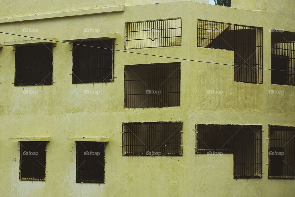 Yellow exterior of a building with no doors and windows 