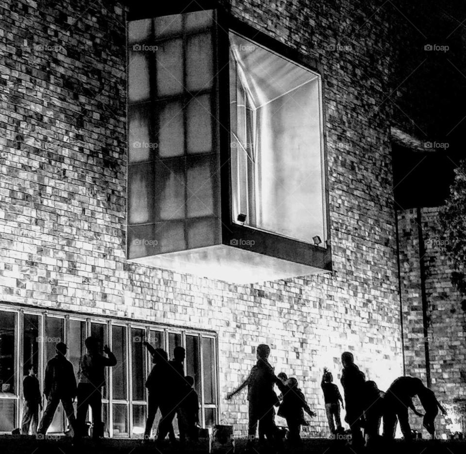 World in black and white: a sporting club night activity at outside of art museum, that big window was an installation art works to be set on the wall.