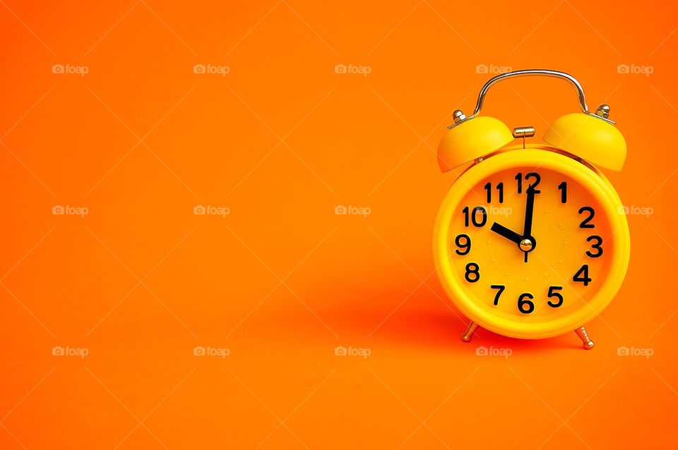 Alarm clock isolated on orange background with copy space 