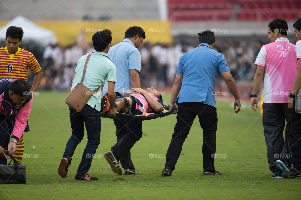 Field officer carry injured football athlete out of the field 