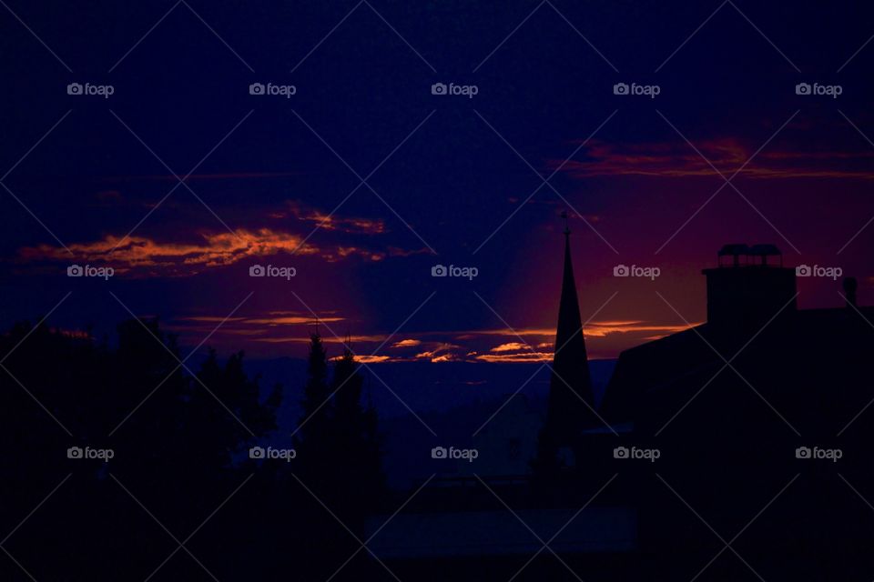 Silhouette of trees and built structure during sunset