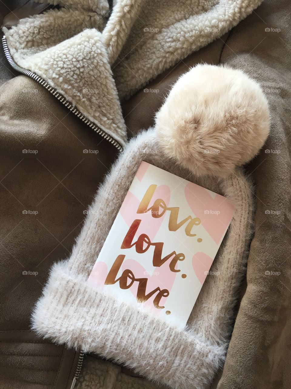 Flat lay items. Winter hat, card with inscription love lying on coat