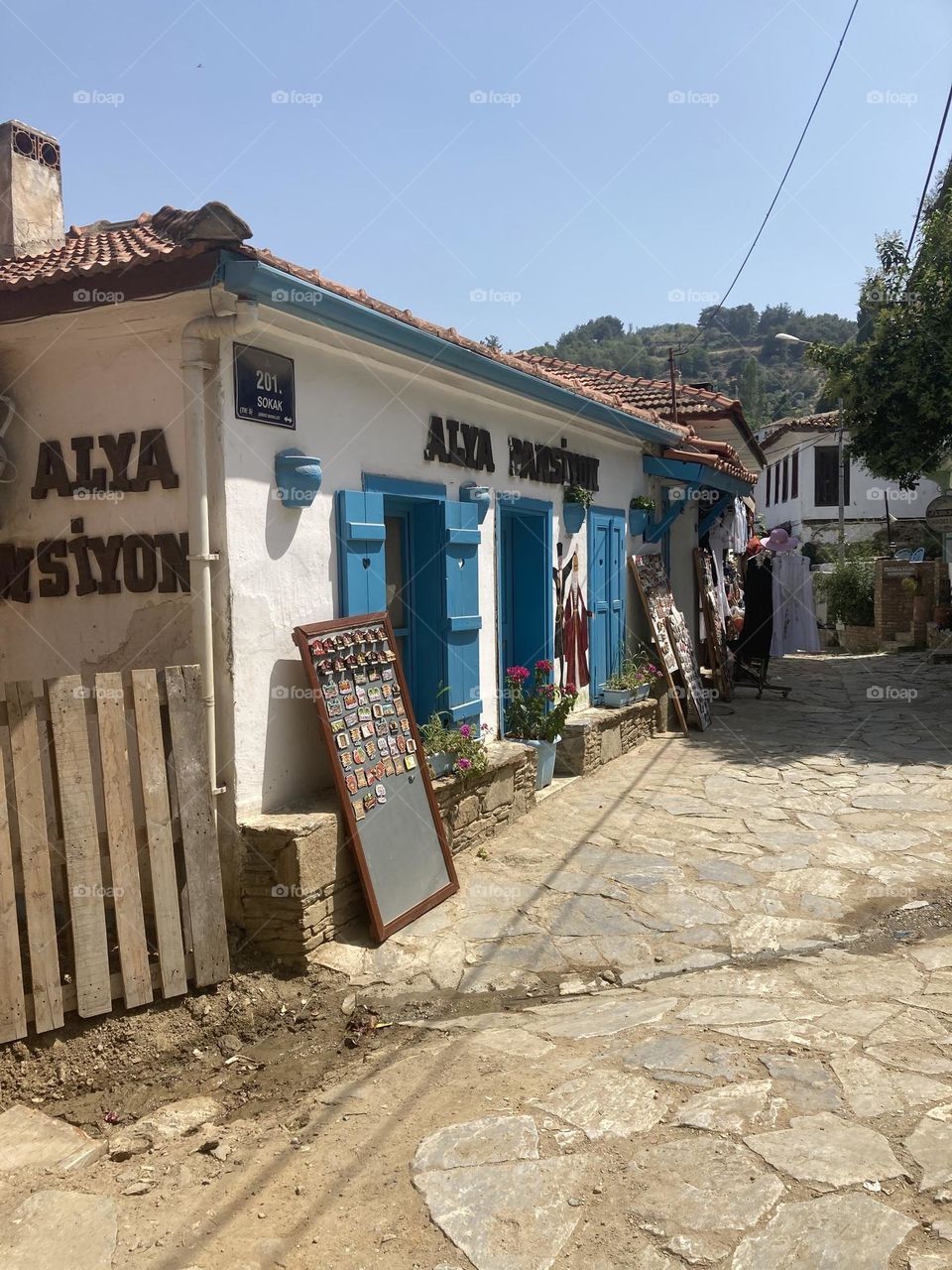 Greek village in Turkey. Blue sky and tall palm trees. Sunsets and sunny days. Summertime in Kusadasi. Vacation travel in Turkey . Summer view. Sunny day during vacation 