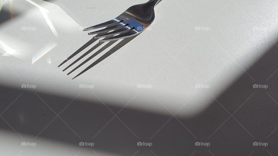 Not Ordinary Fork- a fork with the play of lights with the sun and a mirrow