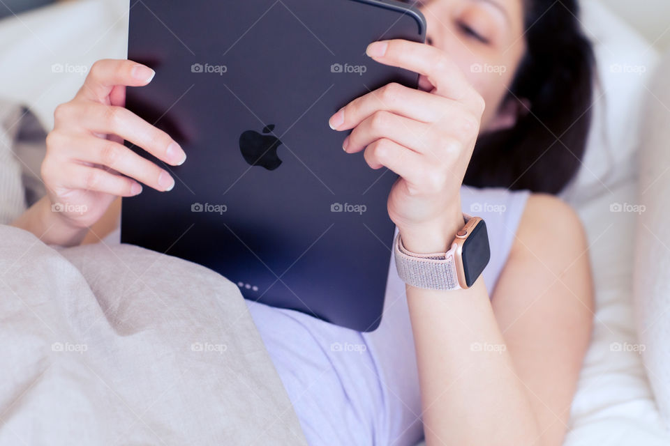 A lady using and iPad and wearing an Apple Watch 