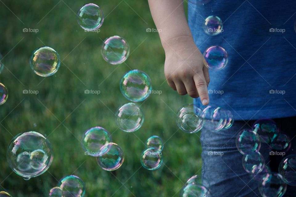 Little boy popping bubbles 